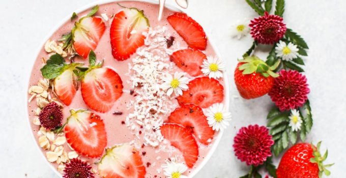 slice strawberry fruit on fruit shake with petaled flowers